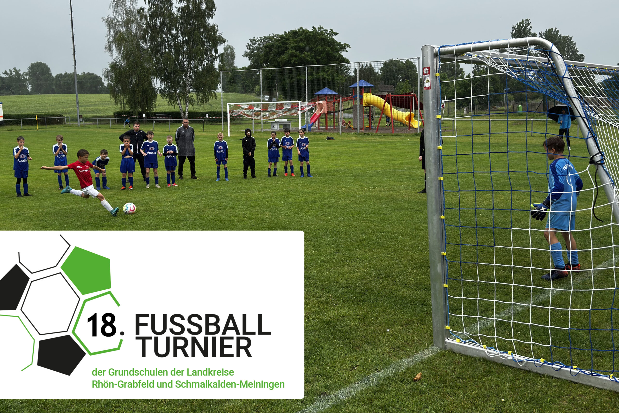 Mehrere Grundschüler spielen vor einem Fußballtor und versuchen ins Tor zu treffen.