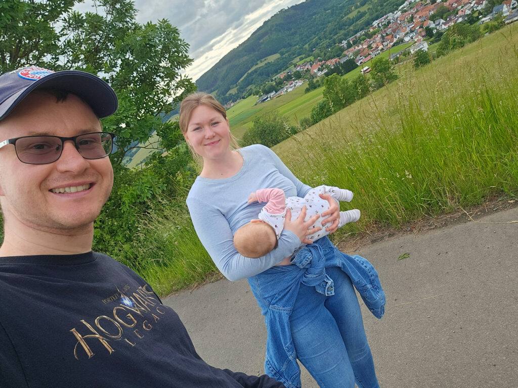 Eine kleine Familie mit einem Baby verbringt gemeinsam Zeit in der Natur und genießt einen Ausflug im Freien.