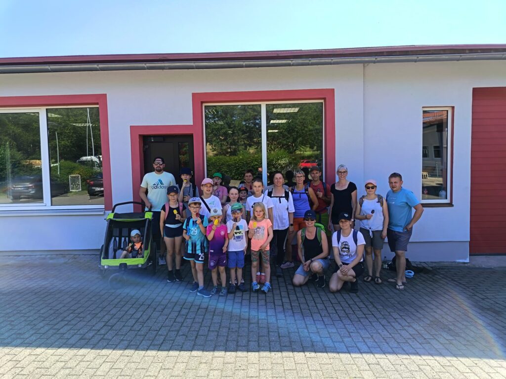 Kinder und Erwachsene des Kindertraditionsvereins Helmershausen genießen vor Beginn ihrer Sommerwanderung ein Eis.