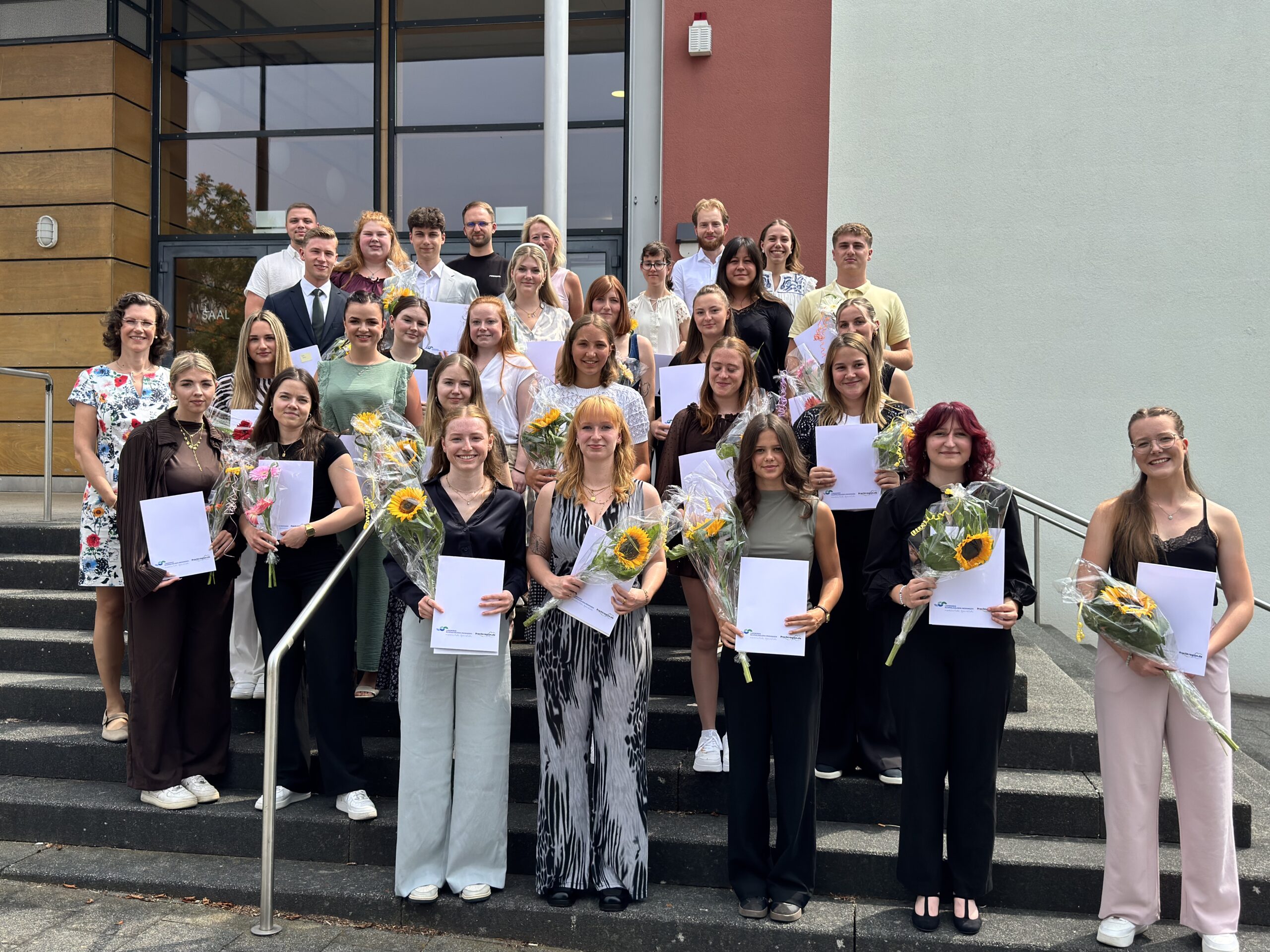 Gruppenbild mit den Absolventen und den neuen Auszubildenden sowie weiteren Vertretern des Landratsamtes
