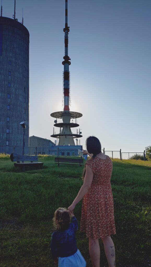 Gipfelglück mit Nachwuchs: Heidi Kaufmann und ihr Nachwuchs genießen den Blick auf den markanten Aussichtsturm des Inselsbergs bei tiefstehender Abendsonne.